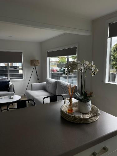 a living room with a couch and a table with flowers at Relax at Jollie-Cozy 3-Bedroom Home, Central Twizel in Twizel