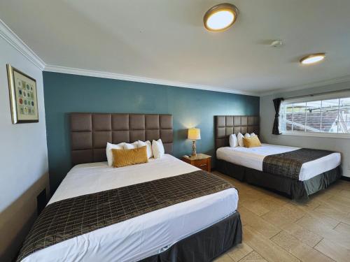 a hotel room with two beds and a window at Sunrise Inn in Wildwood