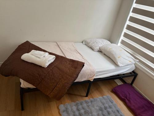 a bed with two towels sitting on top of it at Sandell Place in Oshawa