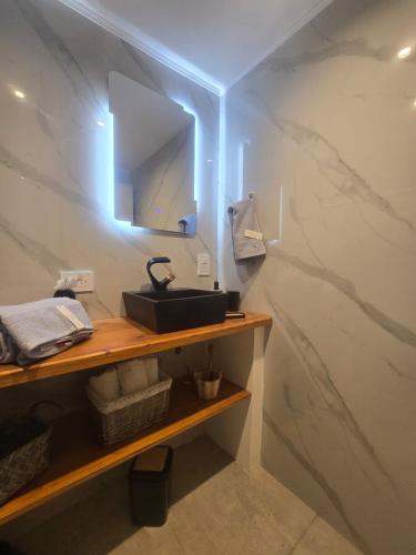 a bathroom with a sink and a mirror on a wall at Casa Malbec en Los Molles in Las Lenas
