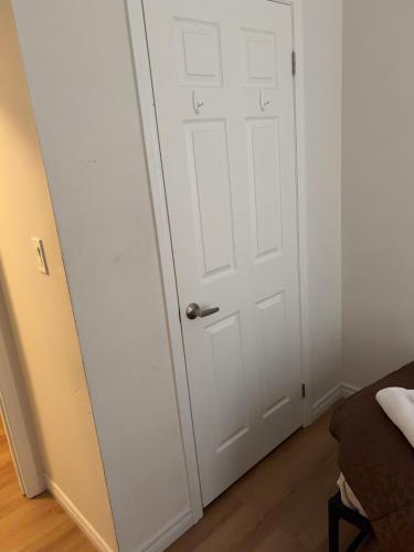 a white door in a room with a bed at Sandell Place in Oshawa