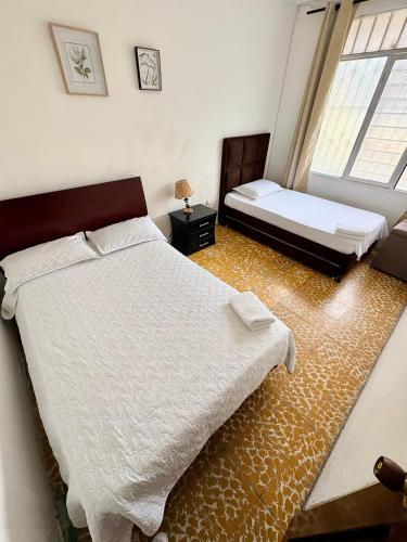 a bedroom with two beds and a window at Apartamento cerca a la Basilica Buga valle in Buga