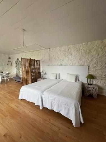 a bedroom with a large white bed in a room at Casa do Cacto - Studio Flat in Madalena