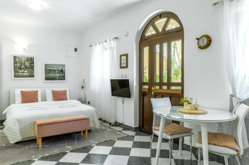 a white bedroom with a bed and a table at S&P City Center Apartments in Kotor