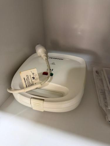 a white toilet in a white room with a sticker on it at Dpto centro CDE in Ciudad del Este