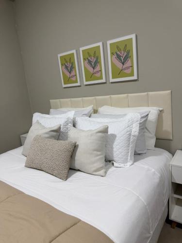 a white bed with white pillows in a bedroom at Dpto centro CDE in Ciudad del Este