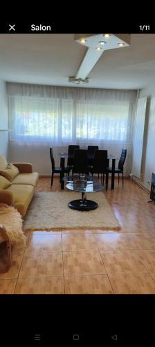 a living room with a couch and a table and chairs at Chambre spacieuse - appart sympa chez l'habitant in Saint-Herblain