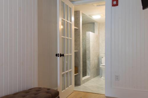 a bathroom with a toilet and a door to a shower at Marginal Way House in Ogunquit