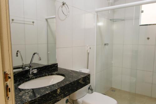 a bathroom with a sink and a toilet at Paramirim Palace Hotel in Paramirim
