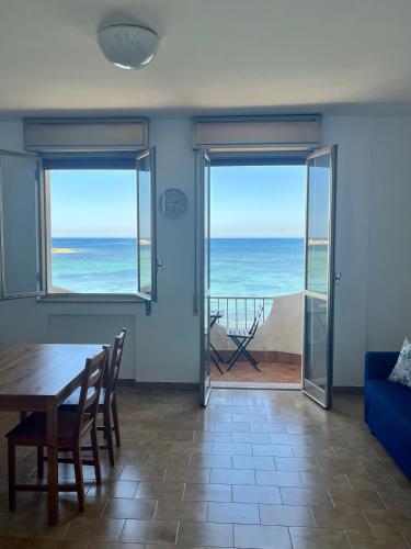 a dining room with a table and a view of the ocean at La terrazza sul mare, 44 in Marzamemi