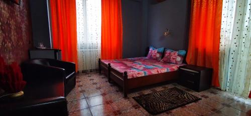 a bedroom with red curtains and a bed and a chair at Max - Mamaia Nord in Mamaia Sat/Năvodari