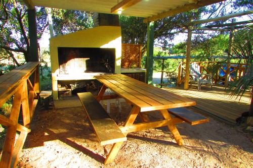 a wooden picnic table with a fireplace on a deck at La Nueva Ensenada in La Paloma