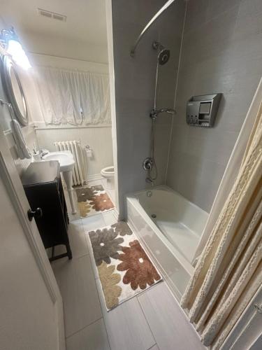 a bathroom with a tub and a toilet and a sink at Dougs house in Niagara Falls