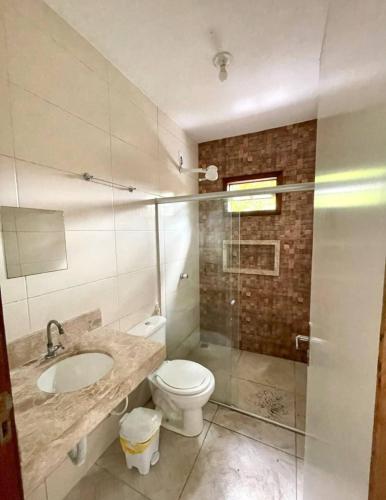 a bathroom with a toilet and a sink and a shower at Casa das Flores in Prado