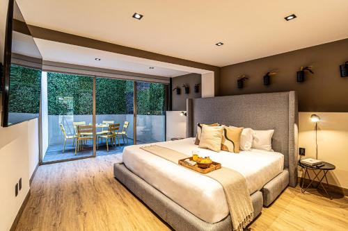 a bedroom with a bed and a balcony with a table at Casa Horacio by Kukun in Mexico City