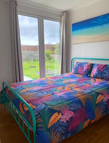 a bedroom with a colorful bed and a window at Coronet Bay Beach Cabin in Coronet Bay