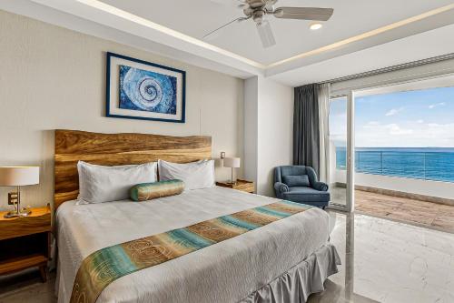 a bedroom with a bed and a chair and a window at Modern condo with ocean views, rooftop infinity pool & central AC in Puerto Vallarta