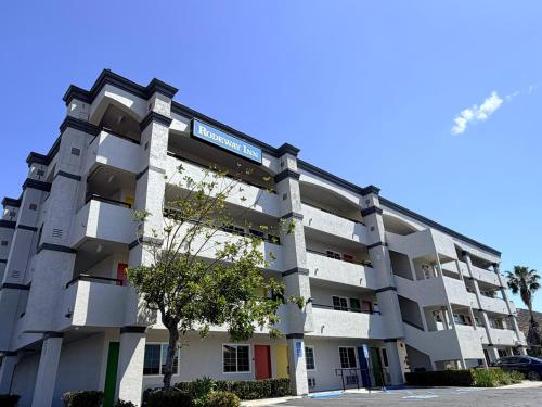 an apartment building with a tree in front of it at Rodeway Inn San Diego South San Ysidro Border in San Ysidro