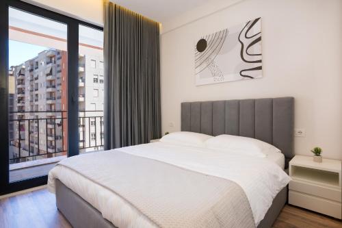 a bedroom with a large bed and a large window at TAO Apartment 2 in Tirana