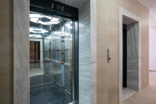 a glass door in a room with a wall at TAO Apartment 2 in Tirana