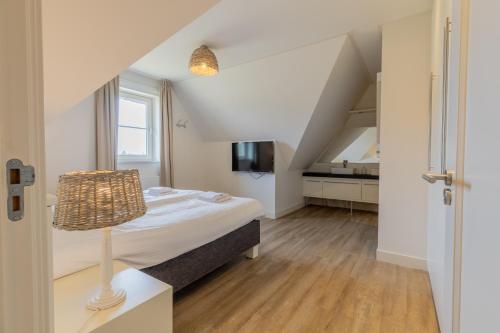 a small bedroom with a bed and a staircase at Binnenduyn 2 in Buren