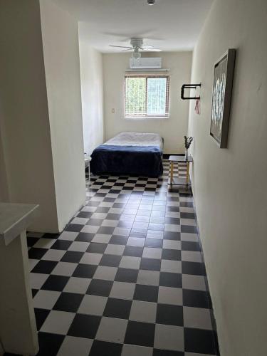 a bedroom with a bed and a checkered floor at Depa 1 sf2 in Hermosillo