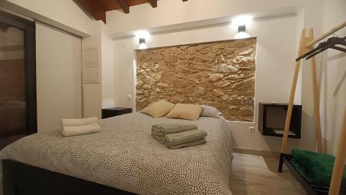 a bedroom with a bed and a stone wall at Casajurada in Pinhel