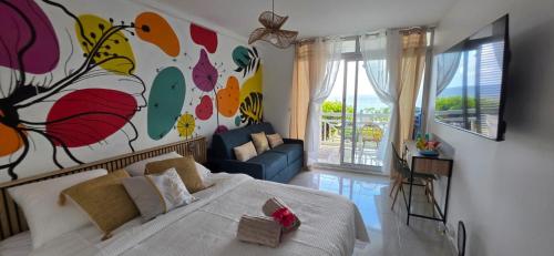 a bedroom with a bed and a painting on the wall at STUDIO La Diamantinoise in Le Diamant