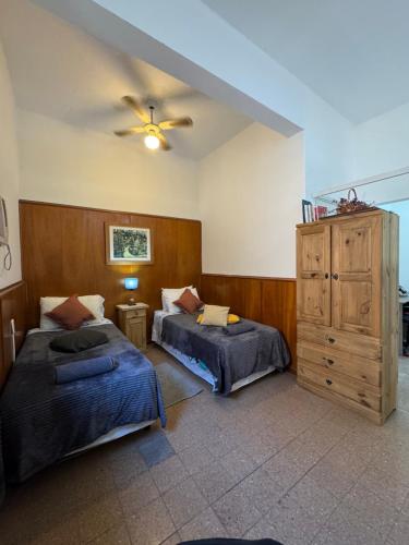 a bedroom with two beds and a ceiling fan at Apto Mitre in San Juan