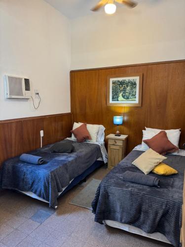 a bedroom with two beds and a tv on the wall at Apto Mitre in San Juan