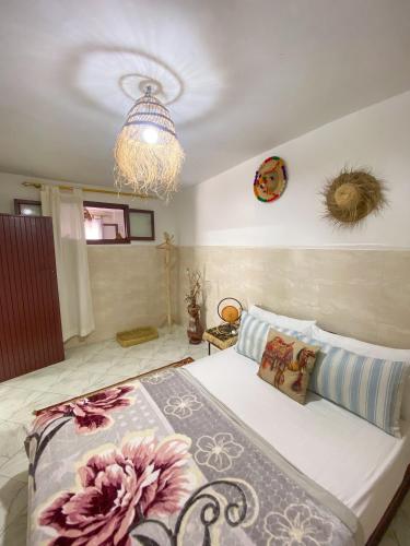 a bedroom with a bed and a chandelier at Dallas Surf Apartment in Agadir