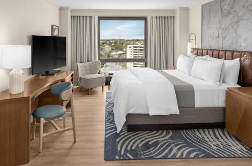 a hotel room with a bed and a desk and a television at The Westin Crystal City Reagan National Airport in Arlington