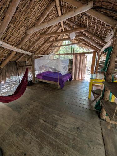 a room with a hammock in a hut at Cabaña Tejon - Casa Corazon Mazunte in Mazunte