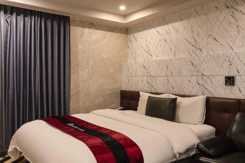 a bedroom with a large bed and a chair at Camp Hotel in Seoul