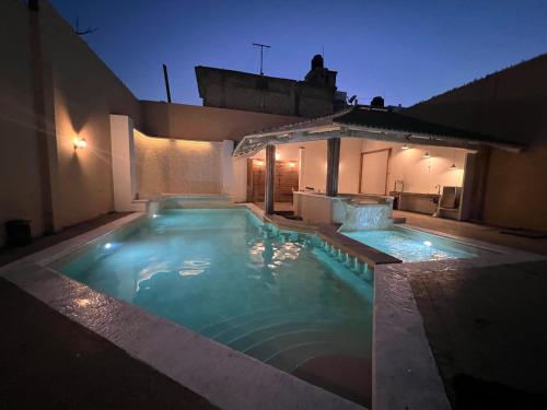 a swimming pool in the backyard of a house at night at CASA con alberca, súper ubicación. Puerto de Veracruz in Veracruz