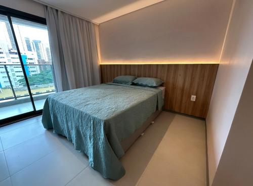 a bedroom with a bed and a large window at Flat Beach Class Meireles in Fortaleza