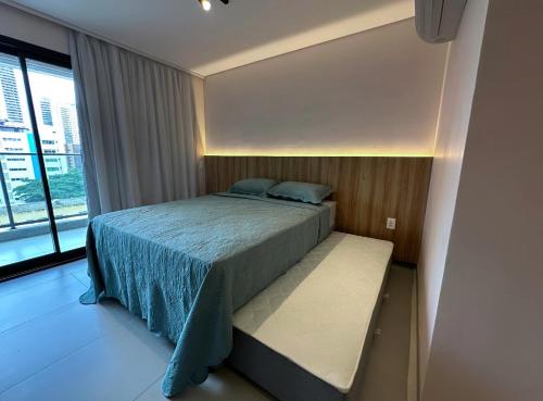 a bedroom with a bed and a large window at Flat Beach Class Meireles in Fortaleza