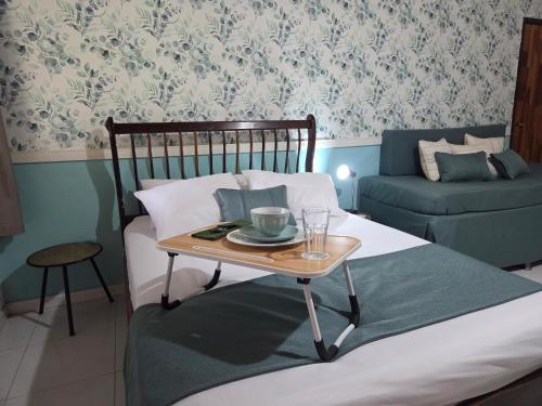 a bedroom with a bed with a table and a couch at Flat 01 Carvalhos de Aldeia km5 in Recife
