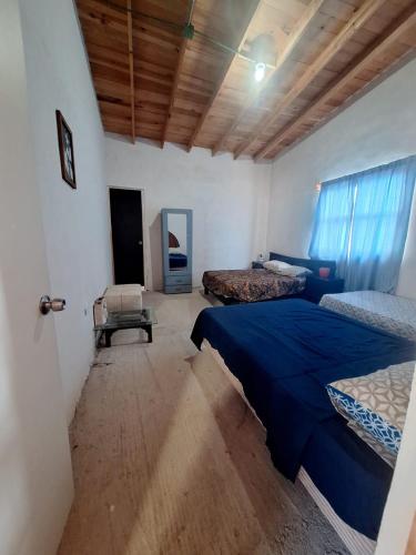 a bedroom with two beds and a table in it at Cabaña Marmolejo in Arteaga