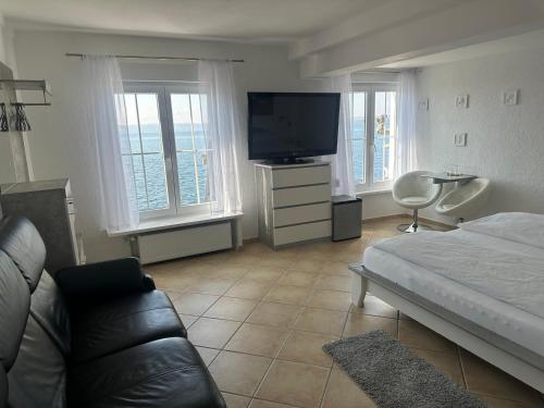 a living room with a bed and a television at Hotel la Perla in Meersburg