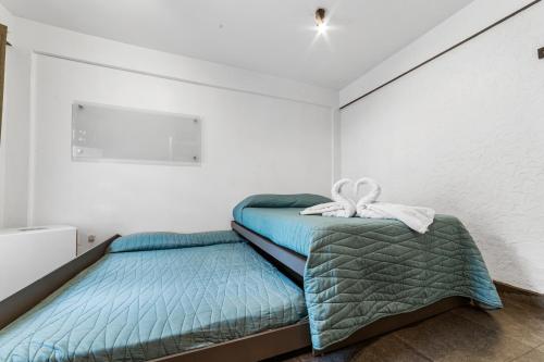 two beds in a room with white walls at Suites CDMX in Mexico City