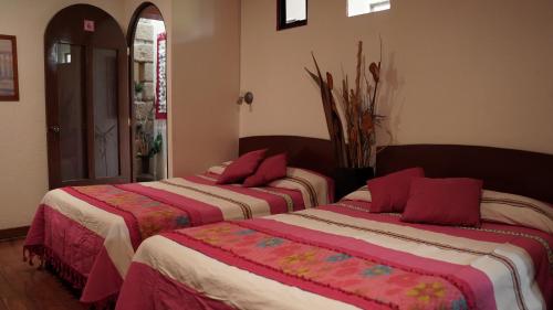 two beds in a room with red pillows on them at Suites CDMX in Mexico City