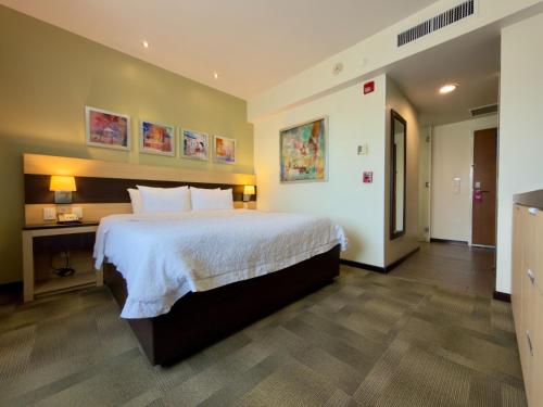 a bedroom with a large bed and a desk at Hampton Inn by Hilton Silao-Aeropuerto, Mexico in Silao