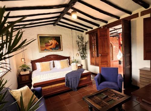 a bedroom with a bed and a blue chair at La Franchesca Hotel Boutique in Tabio