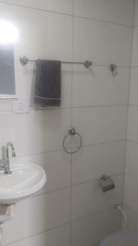 a bathroom with a sink and a toilet and a mirror at Suites Clarinda in Capitólio