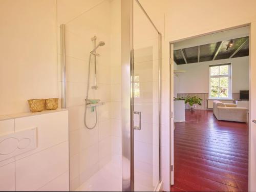 a bathroom with a shower with a glass door at t Voorhuis Kolderveen in Nijeveen