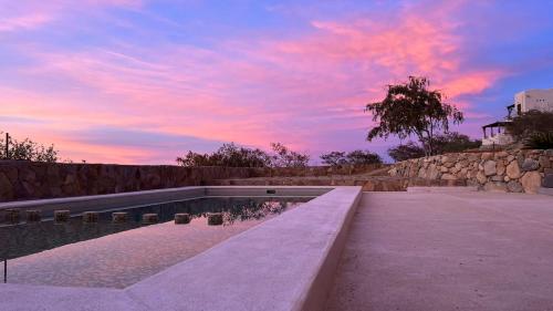 a swimming pool with a sunset in the background at Los Domecitos - Geodesic Dome Retreat in Los Barriles