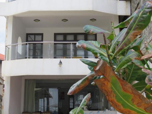 a building with a balcony and a plant at Paradise Bay in Beruwala