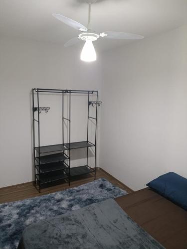 a room with a ceiling fan and a glass shelf at Apto Térreo Próximo HU e Aeroporto Vaga e Ar in Londrina
