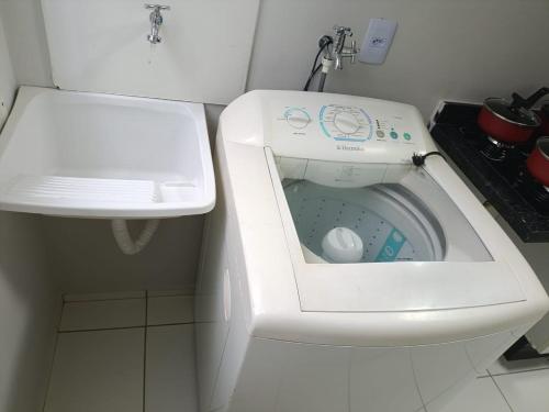 a washing machine in a bathroom next to a sink at Apto Térreo Próximo HU e Aeroporto Vaga e Ar in Londrina
